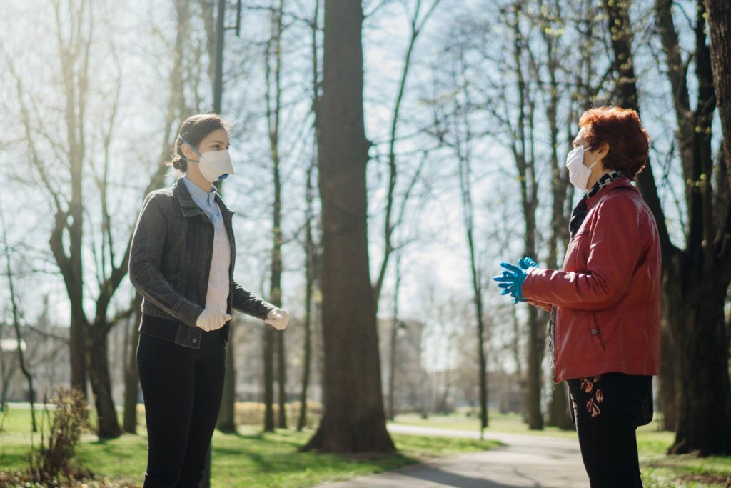 two people conversing while practicing social distancing